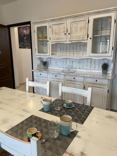 a kitchen with a table with cups and plates on it at B&B MaDie in Castelsardo