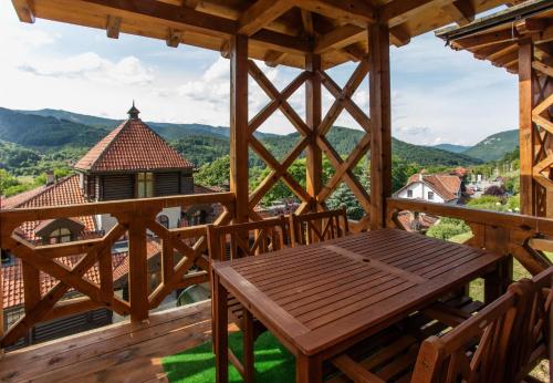 a wooden porch with a wooden table and chairs at Konačište Osmica in Mokra Gora