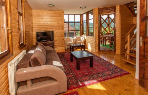 a living room with a couch and a table at Konačište Osmica in Mokra Gora