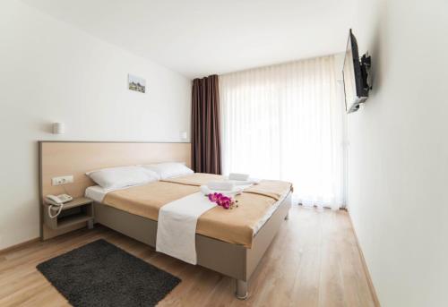 a bedroom with a bed with a flower on it at Centinera Apartments in Banjole