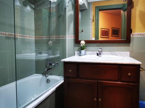 a bathroom with a sink and a tub and a mirror at IMEDA Apartamento SALVIA in Sierra Nevada