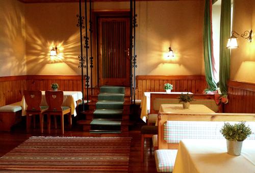 a dining room with tables and chairs and a staircase at Residenz am See in Sankt Kanzian