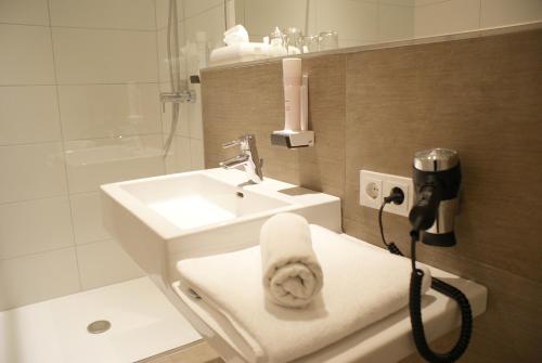 a bathroom with a sink and a toilet with a towel at Hotel Mühlviertler Hof in Schwertberg