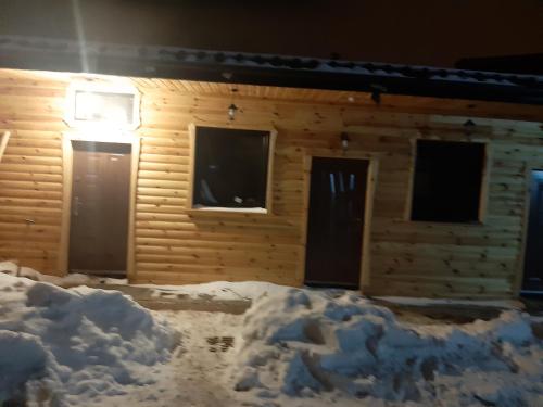 una baita di tronchi con neve di fronte di Pokoj z antresolą a Chełmno