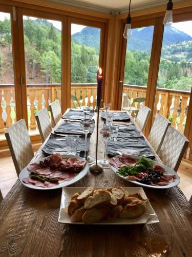 une table en bois avec deux assiettes de nourriture dans l'établissement Riverwood Lodge, à Montriond