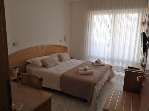 a bedroom with a bed with two towels on it at Hotel Capri in Grado