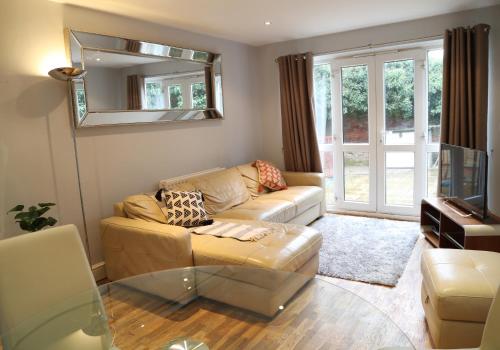 a living room with a couch and a mirror at Letting Serviced Apartments - Sheppards Yard, Hemel Hempstead Old Town in Hemel Hempstead