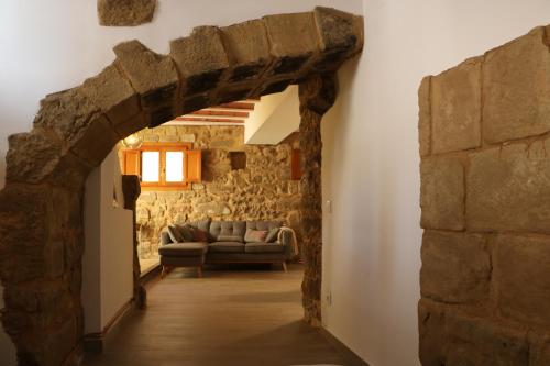 sala de estar con pared de piedra y sofá en Apartamento Casa Mía, en Adahuesca