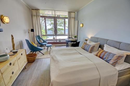 グリュックスブルクにあるfewo1846 Intermar - Marina del Rey - elegantes Studioapartment mit Meerblick und eigenem Strandkorbのベッドルーム(大型ベッド1台、ソファ付)