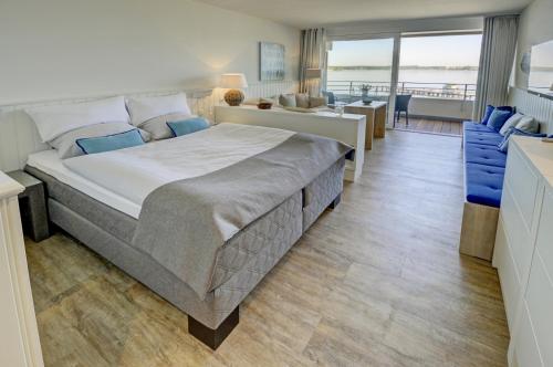 um quarto com uma cama grande e uma sala de estar em fewo1846 Intermar - At the beach - luxuriöses Studioapartment mit Balkon und Meerblick im 2 OG em Glücksburg