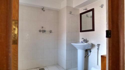 Un baño blanco con lavabo y ducha. en Sunny Guest House and Cafe, en Bhaktapur