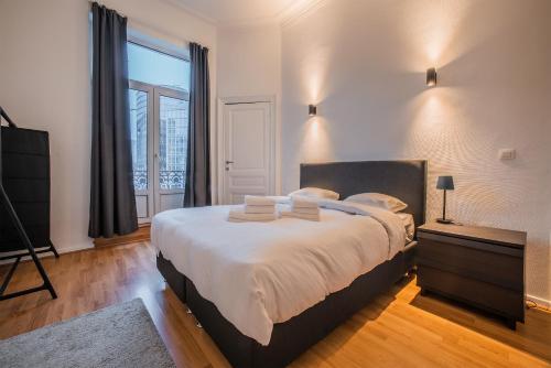 a bedroom with a large bed and a television at Smartflats - Central Brussels in Brussels