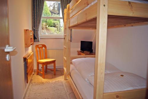 a bedroom with bunk beds with a desk and a chair at Winterberg Appartement 21103 in Winterberg