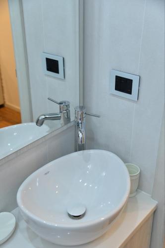 a white sink in a bathroom with a mirror at Bella studios in Kruševac
