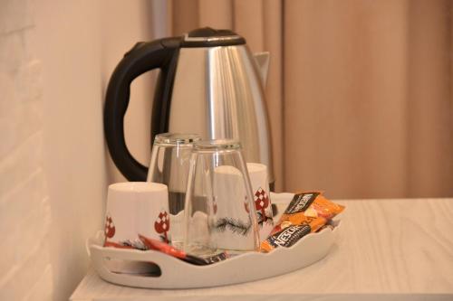 czajnik do herbaty i kubki na stole w obiekcie Bella studios w mieście Kruševac