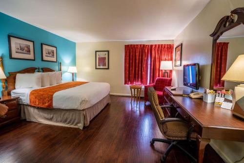 a hotel room with a bed and a desk at Howard Johnson by Wyndham Buena Park in Buena Park