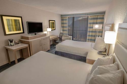 a hotel room with two beds and a television at Wyndham Virginia Beach Oceanfront in Virginia Beach