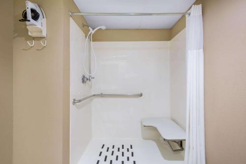 a small bathroom with a shower with a bench at Days Inn & Suites by Wyndham Cuba in Cuba