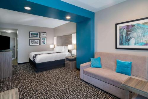 a hotel room with a bed and a couch at La Quinta by Wyndham Forsyth in Forsyth
