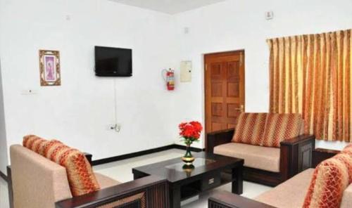a living room with a couch and a table at Apple Breeze Resort in Kotagiri