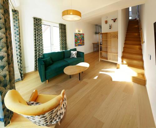 a living room with a green couch and a chair at La Jaguara artistic house in the center of Gdansk in Gdańsk