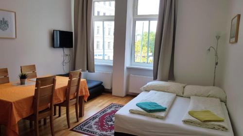 a room with a bed and a table and a window at Apartments Hellwagstraße in Vienna