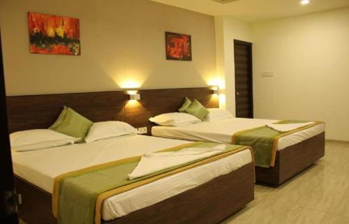 a hotel room with two beds in a room at Hotel Grand Gaayatris in Chennai