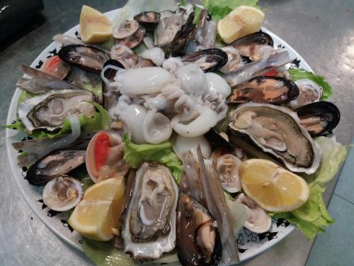 a plate of oysters and vegetables on a table at La Villa dei Gourmets - Struttura Sanificata in Foggia