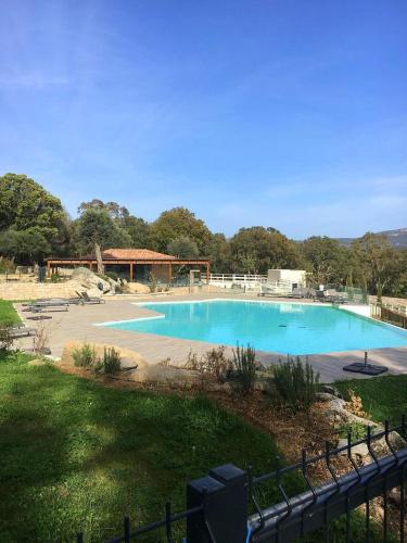 une grande piscine bleue dans une cour dans l'établissement Résidence Standing Domaine d Arca, à Porto-Vecchio
