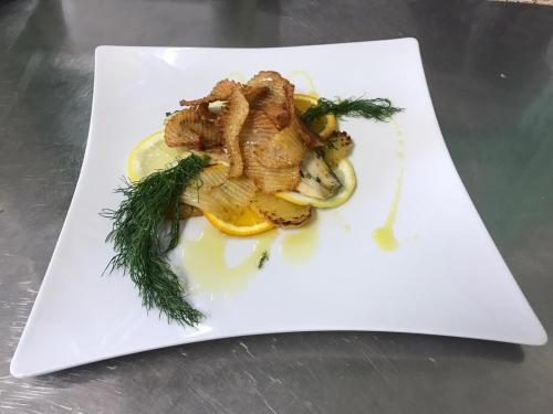 a white plate with some food on a table at La Villa dei Gourmets - Struttura Sanificata in Foggia