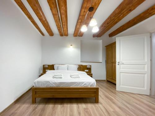 ein Schlafzimmer mit einem weißen Bett und einer Holzdecke in der Unterkunft CERO Brasov in Braşov