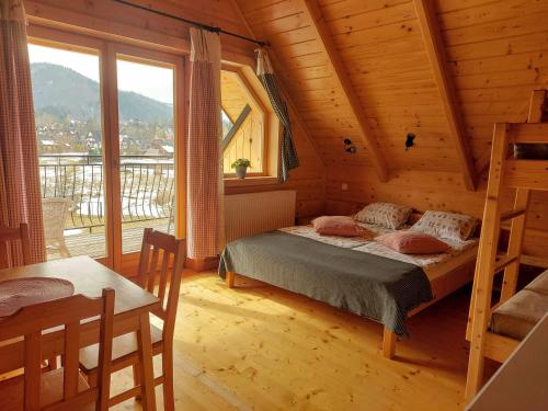 um quarto com uma cama numa casa de madeira em Grażynka em Zakopane