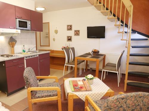 a kitchen and living room with a table and a staircase at Landhotel & Reiterhof Schumann in Triptis