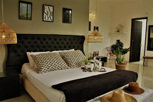 een slaapkamer met een groot bed met een zwart hoofdeinde bij Hotel Boutique Budapez in Honda