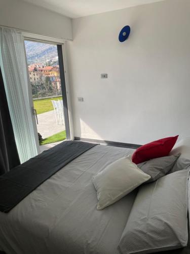 a bed in a room with a large window at La Filanda di Viano in Villa in Tremezzo