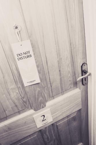 a door with a do not disturb sign on it at Invergarry Room Only Guest House For Adults in Windermere