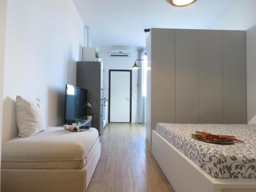 Lazzaretto Apartments في بولونيا: غرفة نوم فيها سرير وتلفزيون