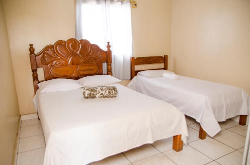 - une chambre avec 2 lits dotés de draps blancs et d'un porte-monnaie dans l'établissement Hotel Shalom Santa Maria do Pará, 