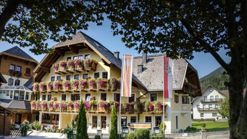 a hotel with flowers on the side of it at Landhotel Schützenhof in Fuschl am See