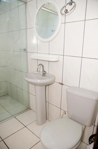 a bathroom with a toilet and a sink and a mirror at Hotel Shalom Santa Maria do Pará in Santa Maria do Pará