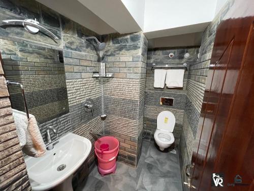 a bathroom with a sink and a toilet at Valley View Residency in Darjeeling