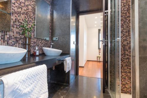 uma casa de banho com 2 lavatórios e um chuveiro em El Soto de Sojuela Luxury Chalet, Golf&Bosque em Sojuela