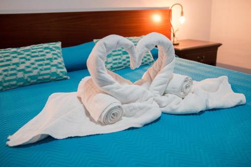 two towels are made to look like swans on a bed at Adega do Pereirinha in São Roque do Pico