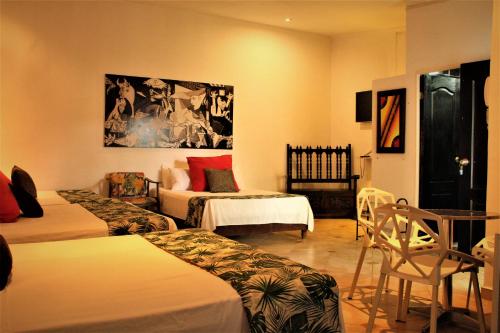 a hotel room with two beds and a table and chairs at Hotel Boutique Budapez in Honda