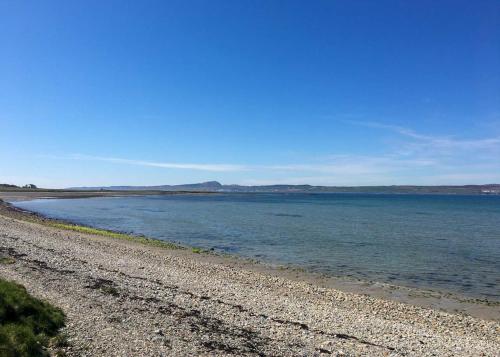 a rocky beach with the ocean in the background at An Cuan Bed & Breakfast in Bowmore