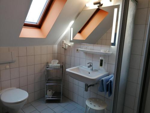 uma casa de banho com um lavatório e um WC em Naturwert Hotel Garni Ursula em Krummhörn