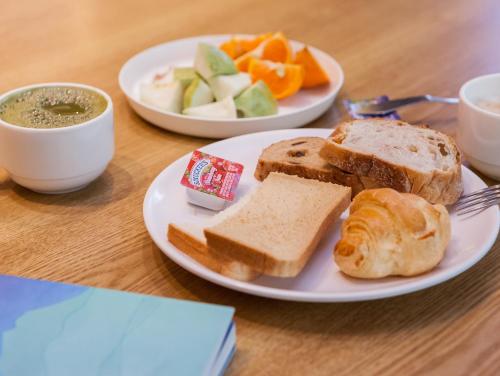 two plates of food with bread and fruit on a table at Taitung Sun forest in Taitung City