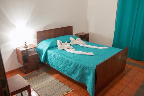 a bedroom with a bed with two towels on it at Adega do Pereirinha in São Roque do Pico