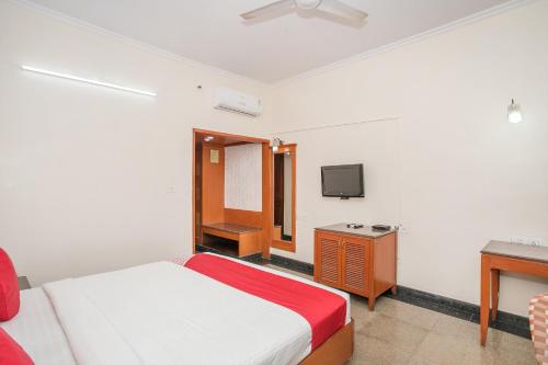 a bedroom with a bed and a tv in it at Hotel Chetan International in Bengaluru