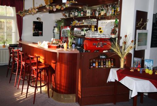 a bar in a restaurant with stools and a counter at Penzion Loreta in Luhačovice